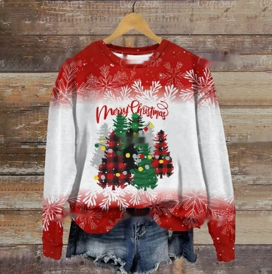 Festive sweater with red and white design featuring Christmas trees and "Merry Christmas" text, hung above denim shorts on a wooden background.