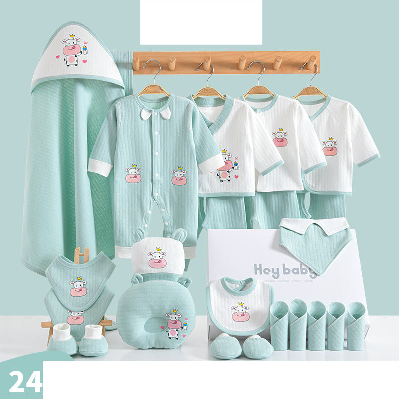 Baby clothing set with mint green and white garments, featuring a cow design. Includes a onesie, tops, pants, a bib, hooded towel, and more, arranged on hangers and a table.