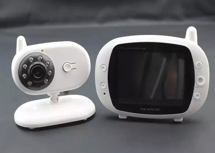 A white baby monitor set with a camera on the left and a display screen on the right. The camera has multiple infrared LEDs, while the monitor features several control buttons.