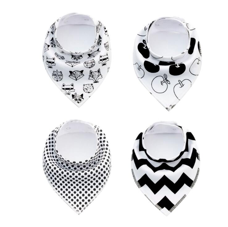 Four baby bandana bibs in monochrome designs: one with cute animal faces, one with apples, one with polka dots, and one with zigzag stripes, all neatly displayed.