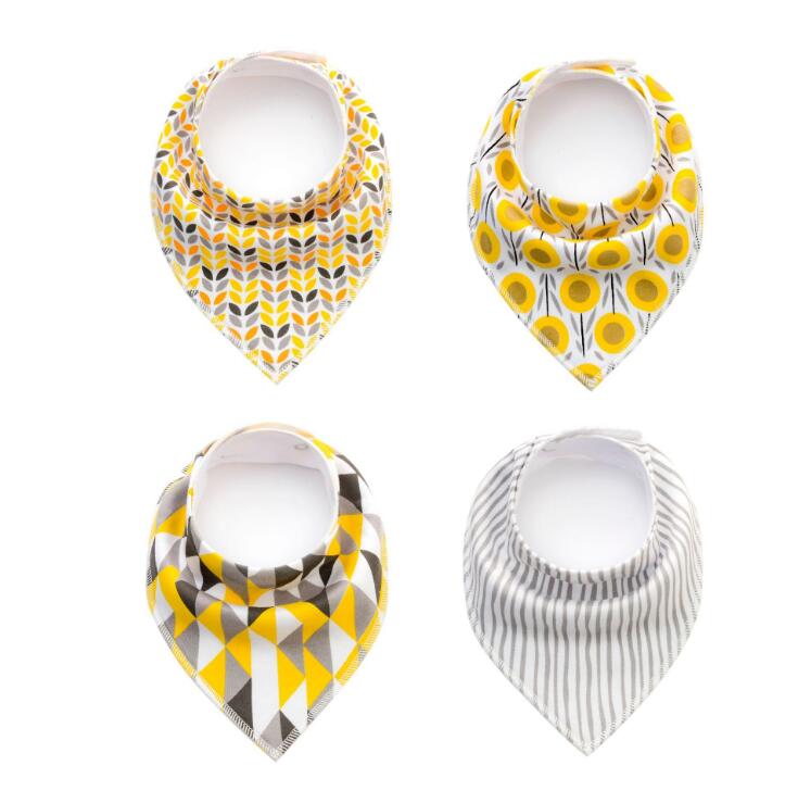 Four baby bibs arranged in a 2x2 grid. Patterns: top left-yellow and gray chevrons, top right-yellow sunflowers, bottom left-geometric shapes, bottom right-gray stripes.