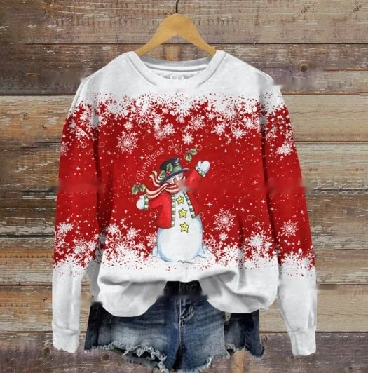 A red and white Christmas sweater with a snowman design, featuring stars and snowflakes, on a wooden hanger. Paired with denim shorts, set against a rustic wooden backdrop.