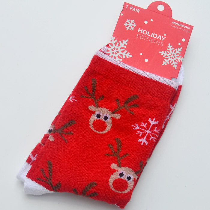 Red socks with reindeer and snowflake patterns, labeled "Holiday Editions." The tag is red with white snowflakes and dots.