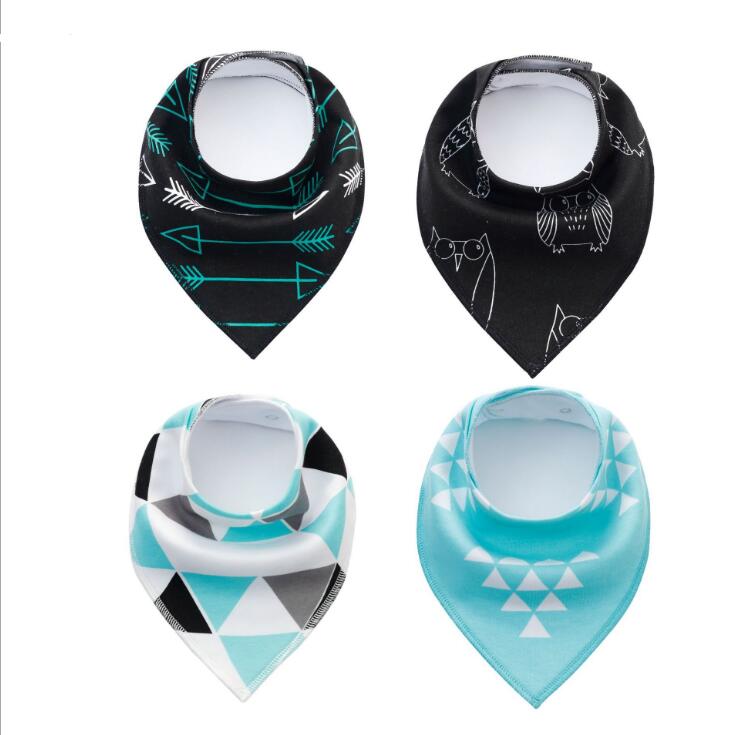 Four colorful baby bandana bibs with patterns: black and teal arrows, black with owl design, geometric triangles in black, teal, and white, and teal with white triangles.