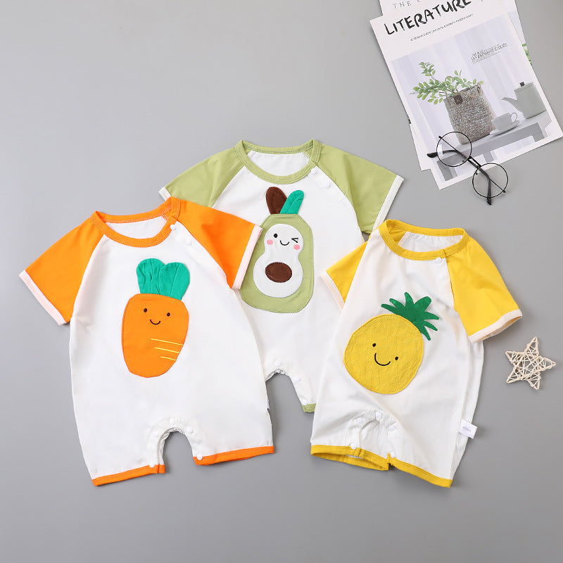 Three baby rompers with cute fruit designs: a carrot with orange sleeves, an avocado with green sleeves, and a pineapple with yellow sleeves, laid beside a magazine and glasses.