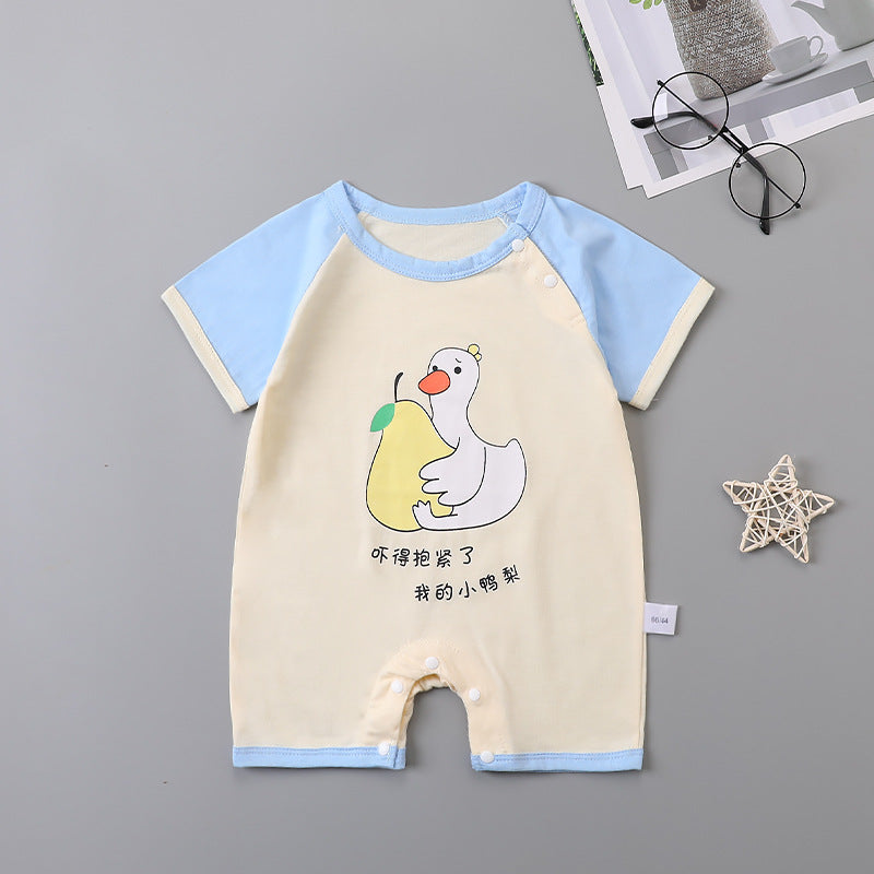 Cream baby romper with light blue sleeves and snaps. Features a duck holding a pear design with Chinese text. Nearby, glasses and a decorative star are on a gray background.