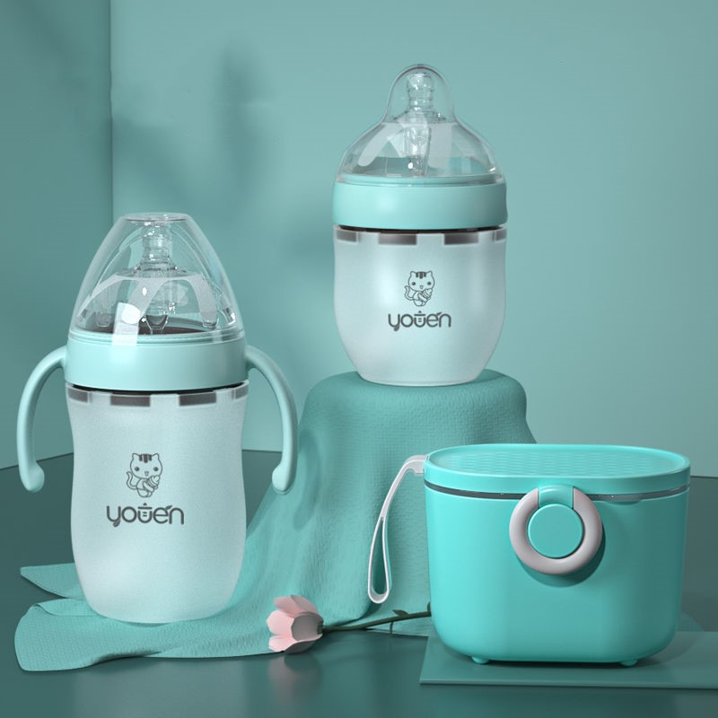 Three pastel teal baby bottles and a lidded container are displayed on a matching teal background. The bottles have handles and clear tops, featuring a cute animal graphic and text.