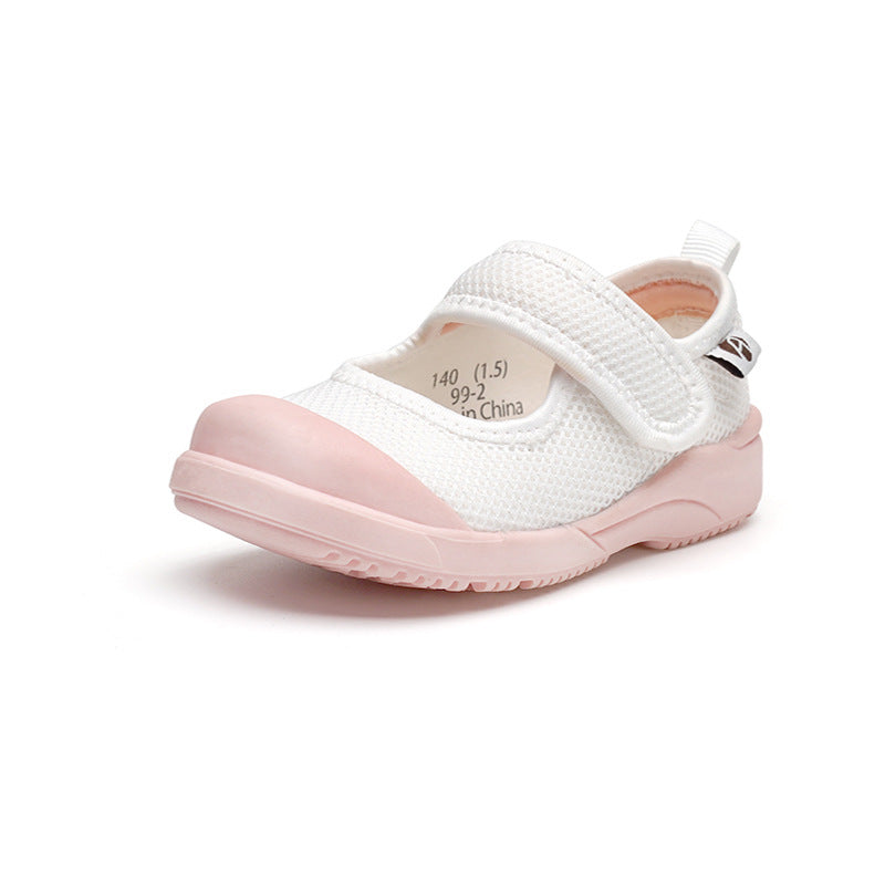 A white children's shoe with a pink toe cap and sole, featuring a mesh texture and a velcro strap for easy fastening, against a white background.