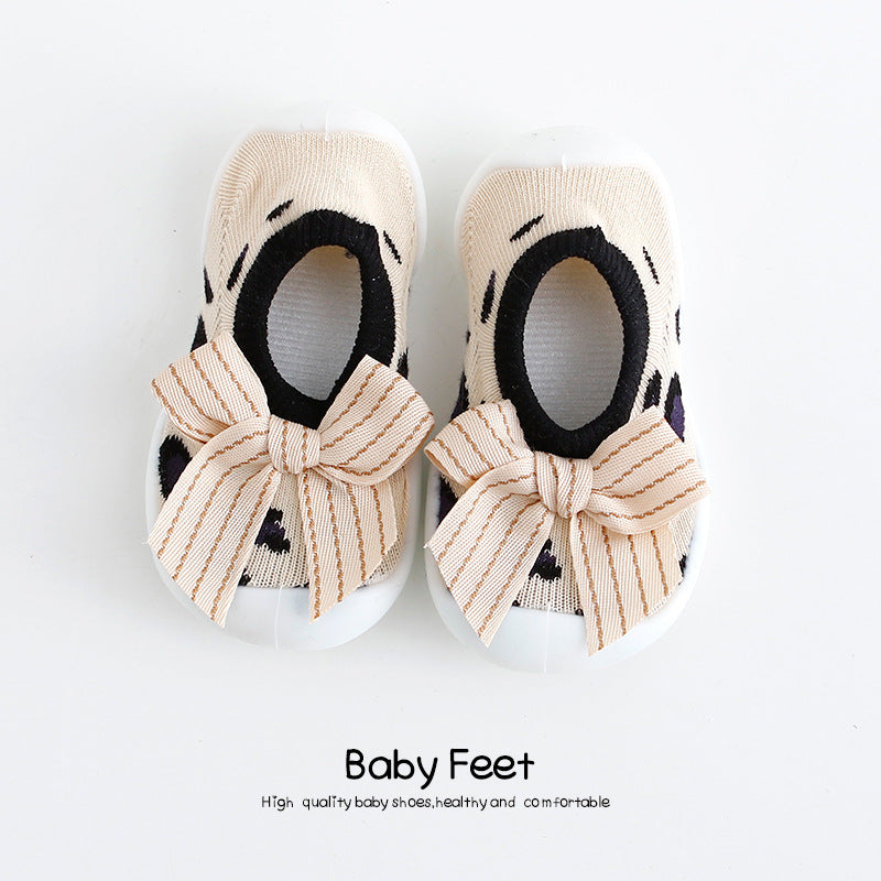 Baby shoes with black spots and large striped bows on a white background. Text below reads "Baby Feet" highlighting quality, health, and comfort.