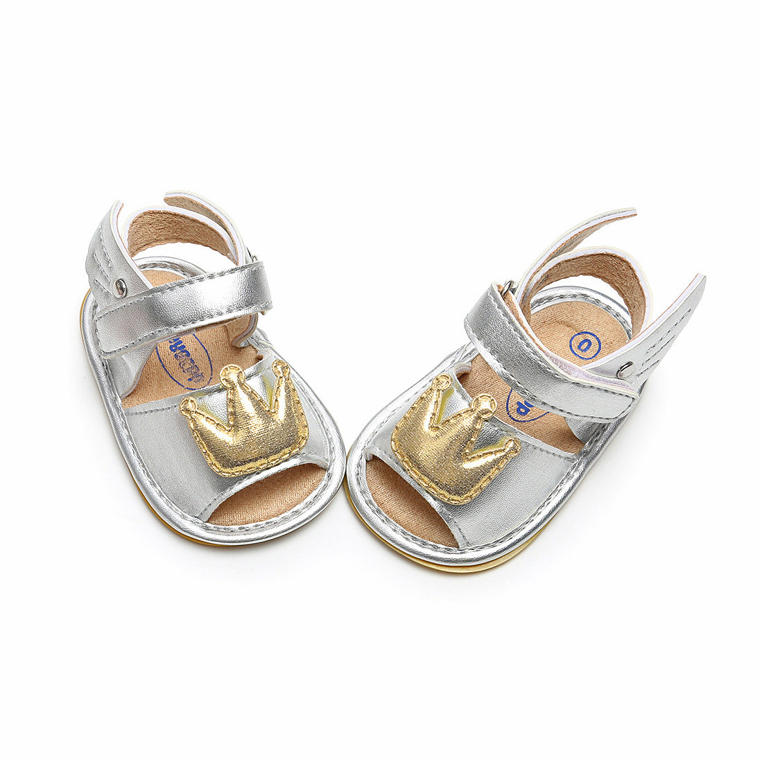Silver baby sandals with open toes and adjustable straps, featuring a gold crown embellishment on the front.