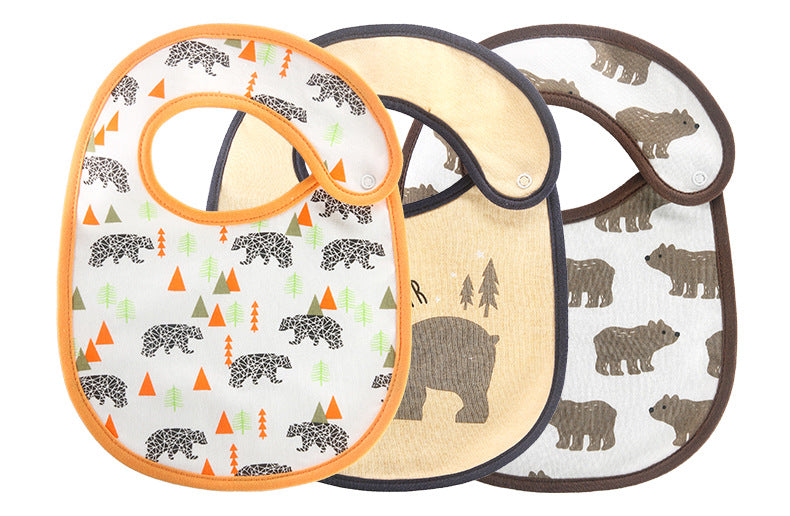 Three baby bibs featuring bear designs are displayed. The first has colorful bears and trees, the second has a large bear with trees, and the third has a pattern of brown bears.