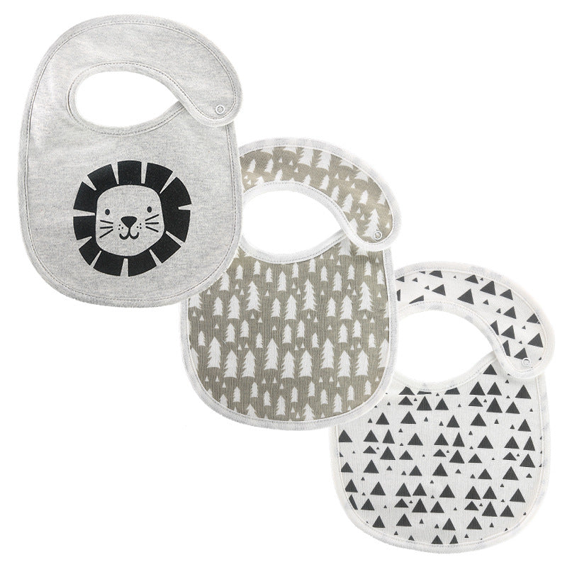 Three baby bibs are displayed: a gray one with a lion face, a taupe one with white tree patterns, and a white one with black triangular patterns.