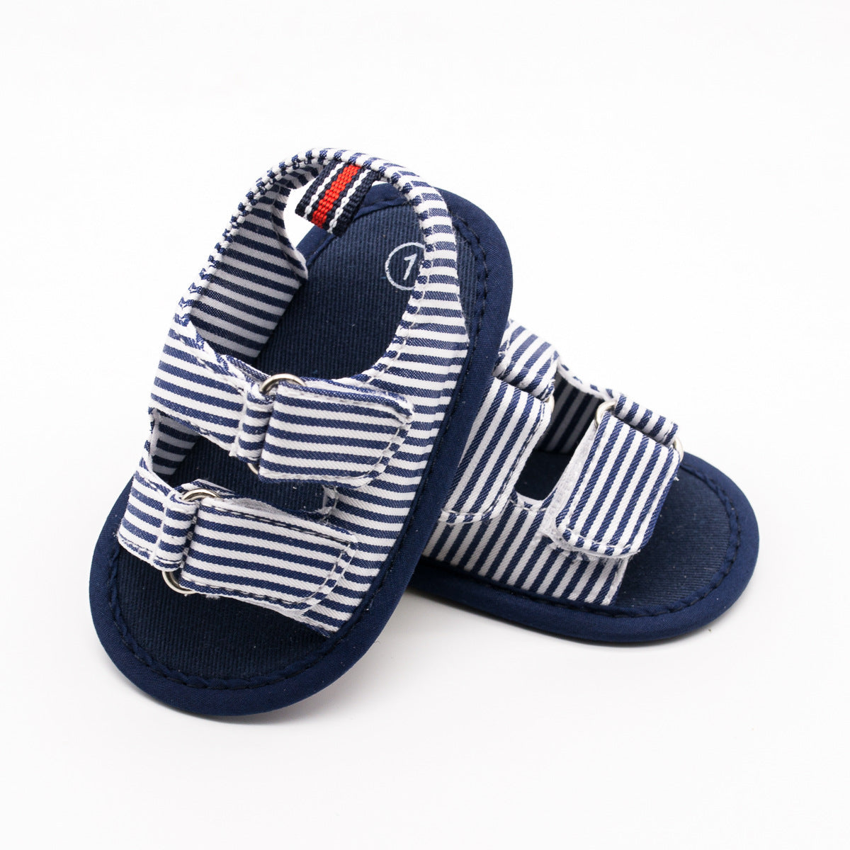 Striped blue and white baby sandals with double buckle straps, featuring navy blue soles and accents. The sandals are displayed against a plain white background.