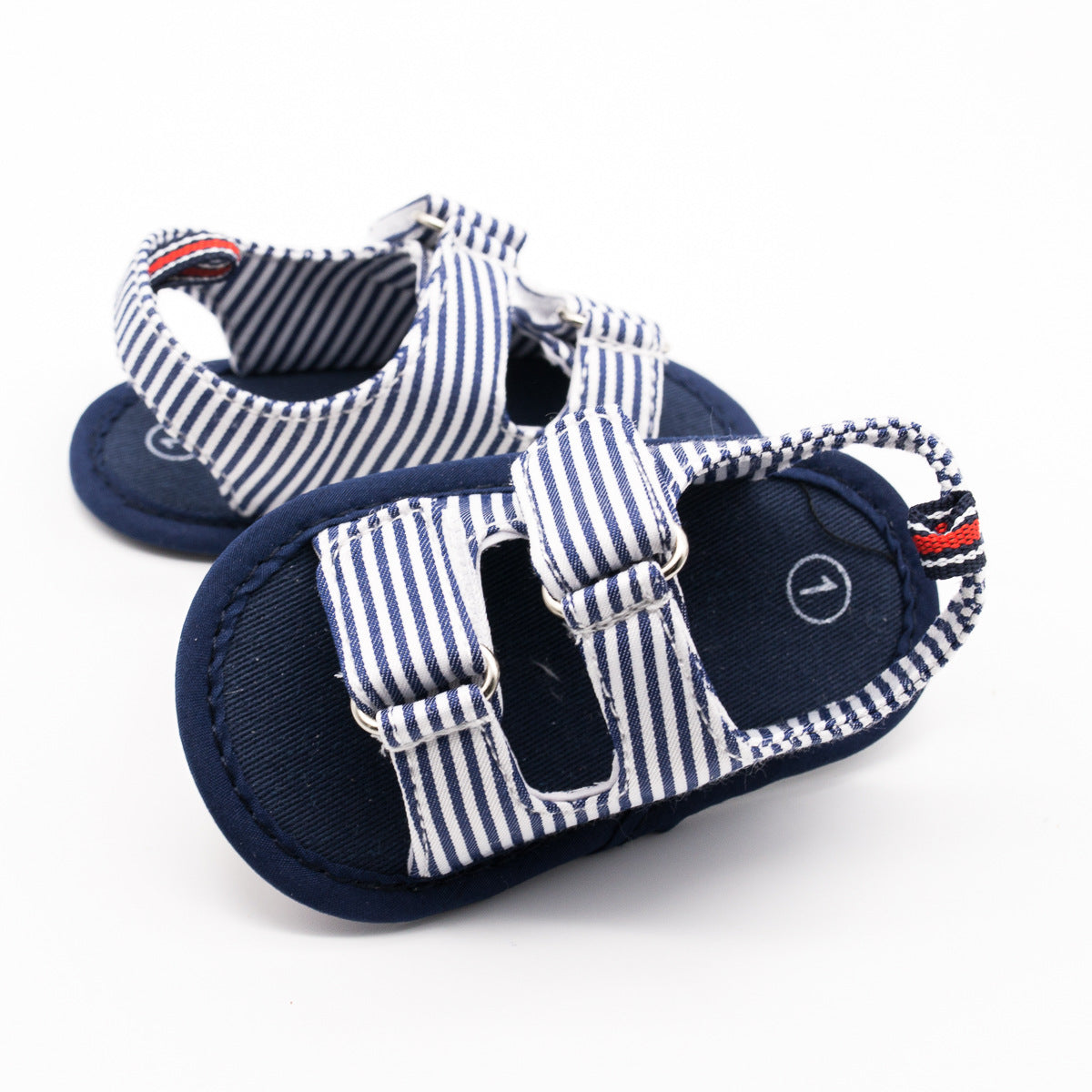Blue and white striped baby sandals with soft soles and adjustable straps, featuring a nautical design. The interior has a subtle round arrow mark, representing size orientation.