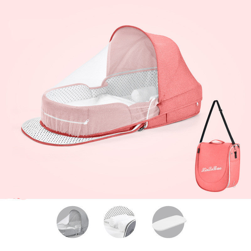 Pink foldable baby bed with a canopy and mesh cover, featuring a polka dot pattern. Includes a matching pink carrying bag with shoulder strap. Perfect for travel.