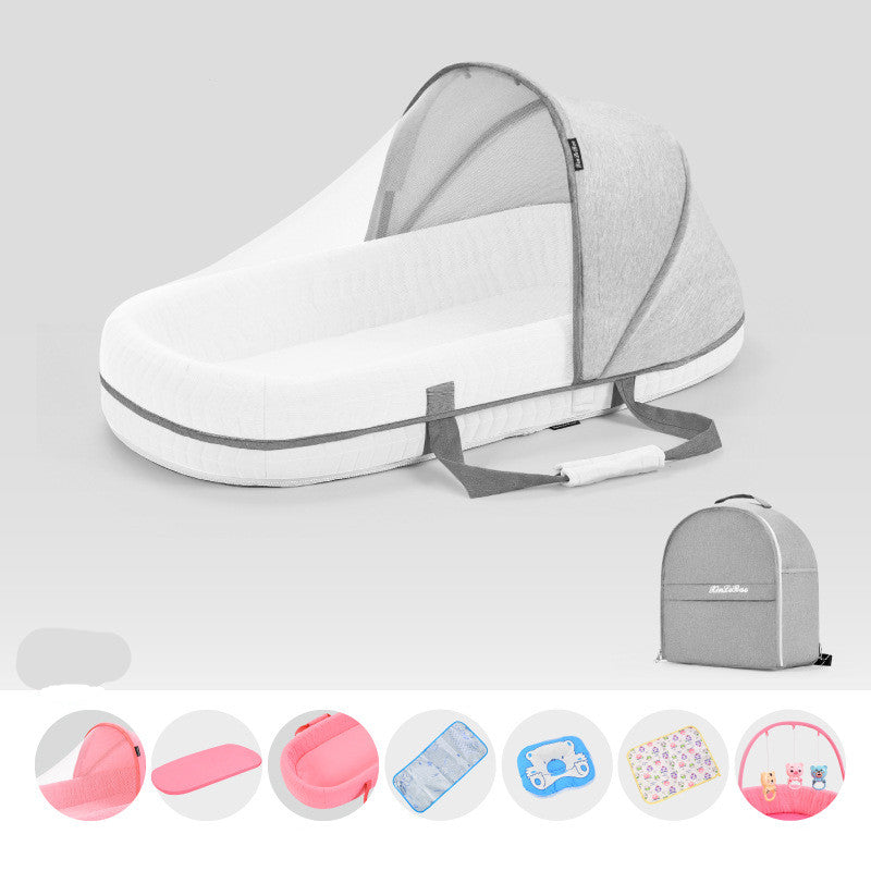 Portable baby bed with gray mesh canopy and carry handle, shown with a matching gray backpack. Includes pink mat, blue cooler bag, bottle, floral pad, and toy storage.