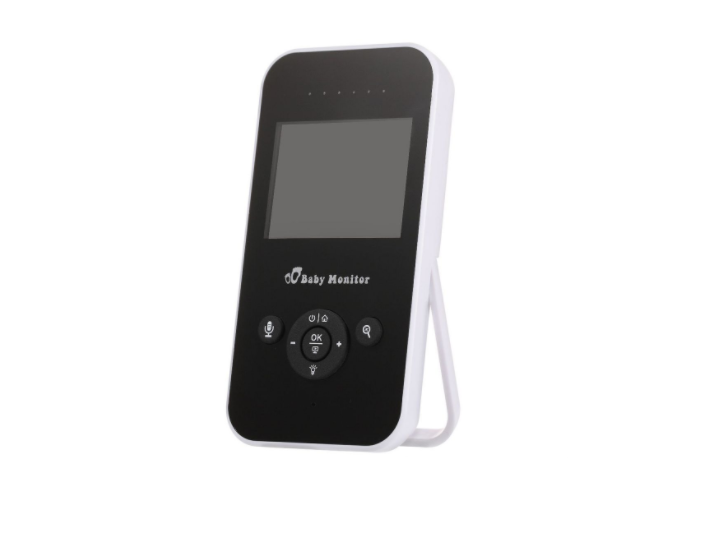 A white and black baby monitor with a screen and control buttons on the front, including microphone and navigation options, standing on its built-in stand.