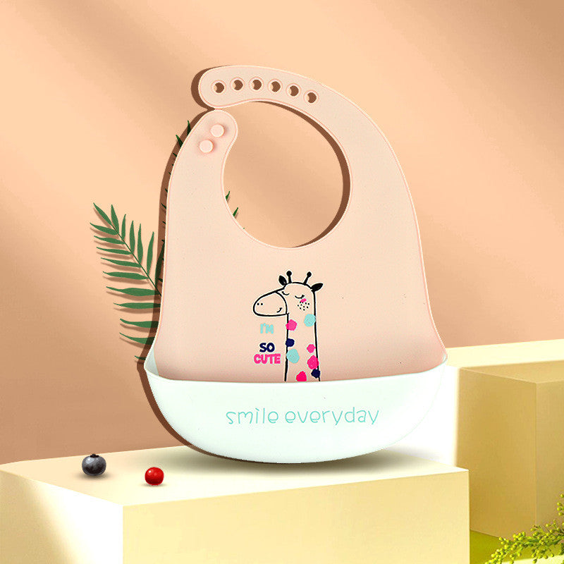 Pink baby bib with a cartoon giraffe and the text "I'm so cute." Features a food-catching pocket with "smile everyday" written on it. Background includes a leaf and decorative balls.