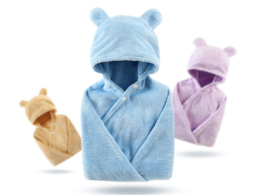 Three soft baby blankets with bear ear hoods in blue, beige, and lilac are displayed. The blankets are buttoned and appear cozy, ideal for infants.