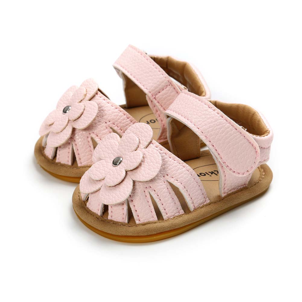 Pink toddler sandals with hook-and-loop straps and decorative flower accents on the front. The sandals have a soft sole and are designed with textured leather material for comfort.