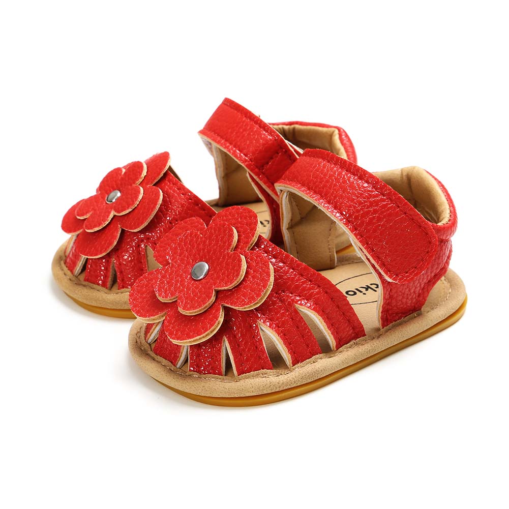 Red toddler sandals with floral decorations and Velcro straps, featuring textured leather and soft soles, designed for comfort and style.
