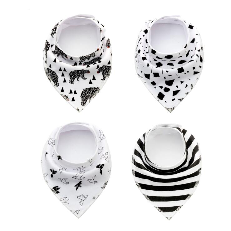 Four baby bandana bibs with different black and white patterns: bears and triangles, abstract shapes, origami birds, and horizontal stripes.