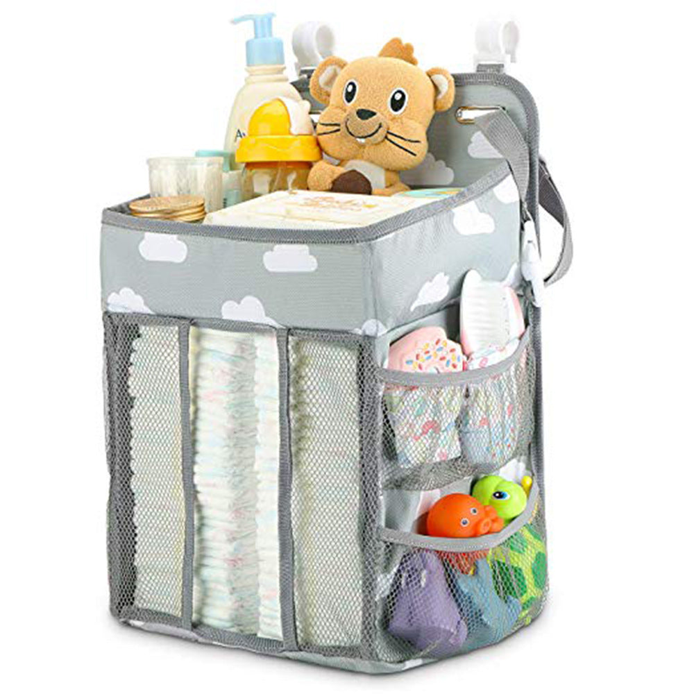 Gray nursery organizer with cloud pattern, filled with diapers, baby lotion, plush toy, and assorted baby essentials in mesh pockets, featuring easy-to-access design.