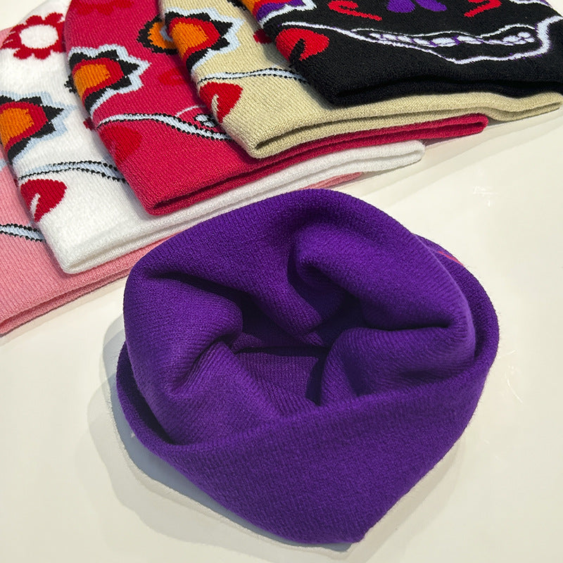 A collection of folded beanies in various patterns and colors, including floral designs and a purple plain one, arranged on a white surface.