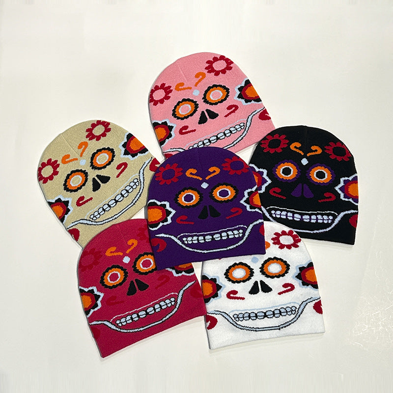 Colorful beanies with sugar skull designs in beige, pink, black, purple, maroon, and white, each featuring vibrant patterns of flowers and swirls.