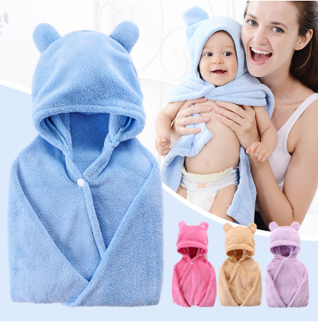 A smiling woman holds a baby wrapped in a blue hooded towel with bear ears. The image also shows the towel in pink, beige, and purple variations.