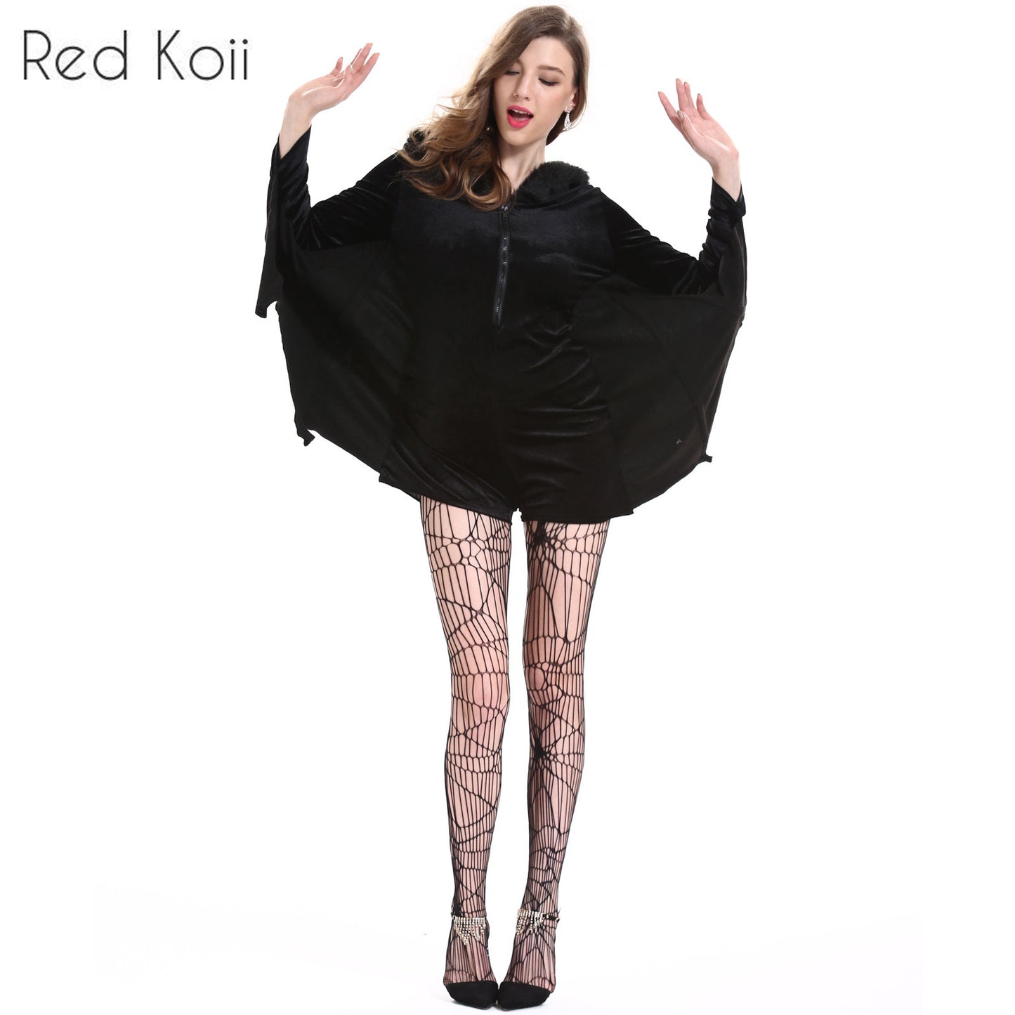 Woman dressed as a bat in a black velvet costume with wing-like sleeves and web-patterned tights. Her arms are raised, and she's wearing pointed black shoes.