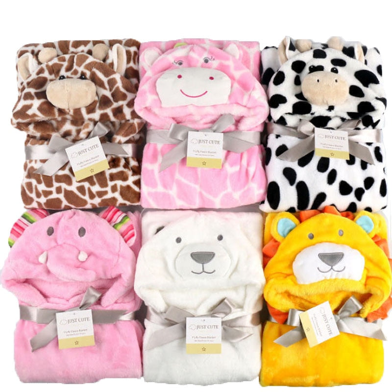 A selection of plush animal-themed blankets folded neatly, featuring designs like giraffe, hippo, cow, elephant, polar bear, and lion. Each blanket is tied with a ribbon.