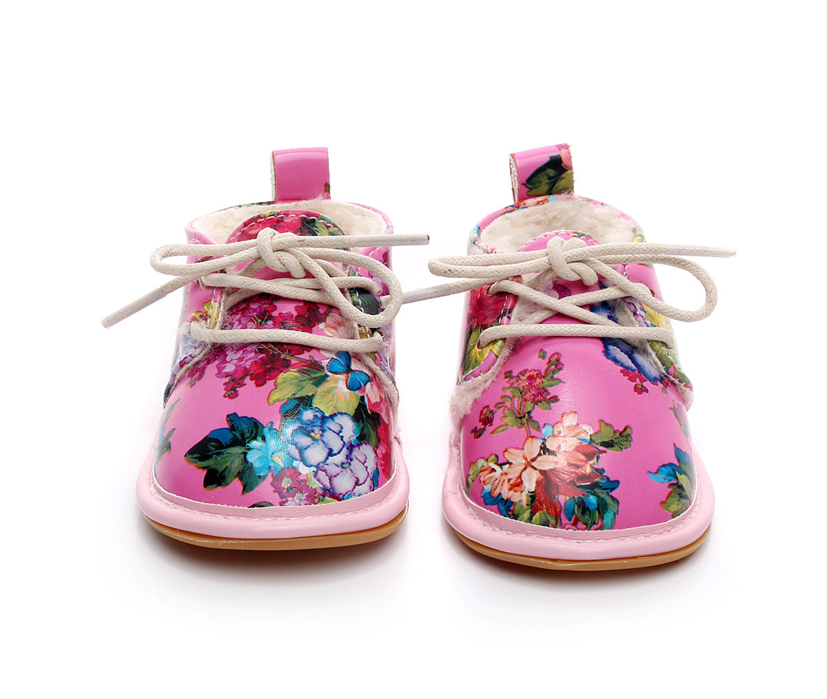 Pink baby shoes with colorful floral patterns, featuring white laces and plush lining. The shoes have a glossy finish and a small pull tab at the back for easy wear.