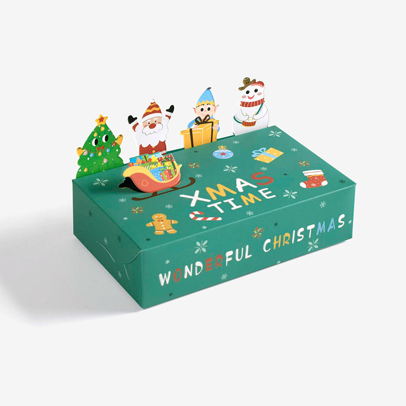 Christmas-themed green box with "XMAS TIME" and "WONDERFUL CHRISTMAS" text, featuring pop-up characters like Santa, elf, snowman, and tree. Decorated with snowflakes and gifts.