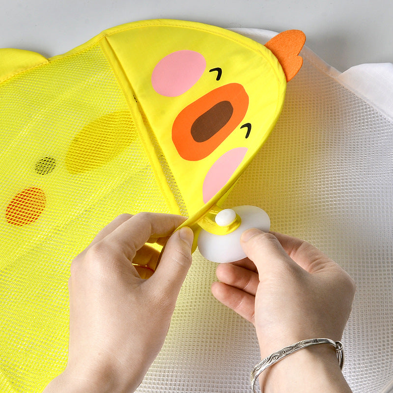 Hands attaching a yellow mesh wall organizer with a cartoon duck design and suction cup.