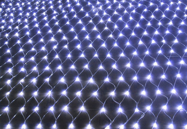 A grid of bright white LED lights creates a glowing, net-like pattern against a dark background, forming an undulating surface of interconnected points of light.