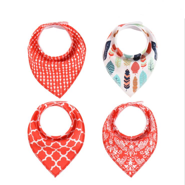Four baby bandana bibs are displayed, each with a unique design: orange arrows, multicolored feathers, orange quatrefoil, and orange floral patterns.