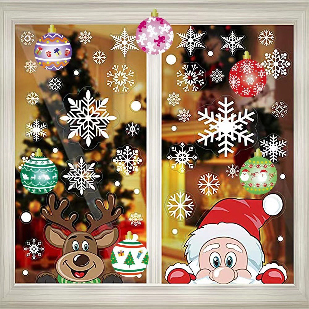 Festive window decals featuring Santa, a reindeer, snowflakes, and colorful ornaments. A Christmas tree glows warmly inside the home.