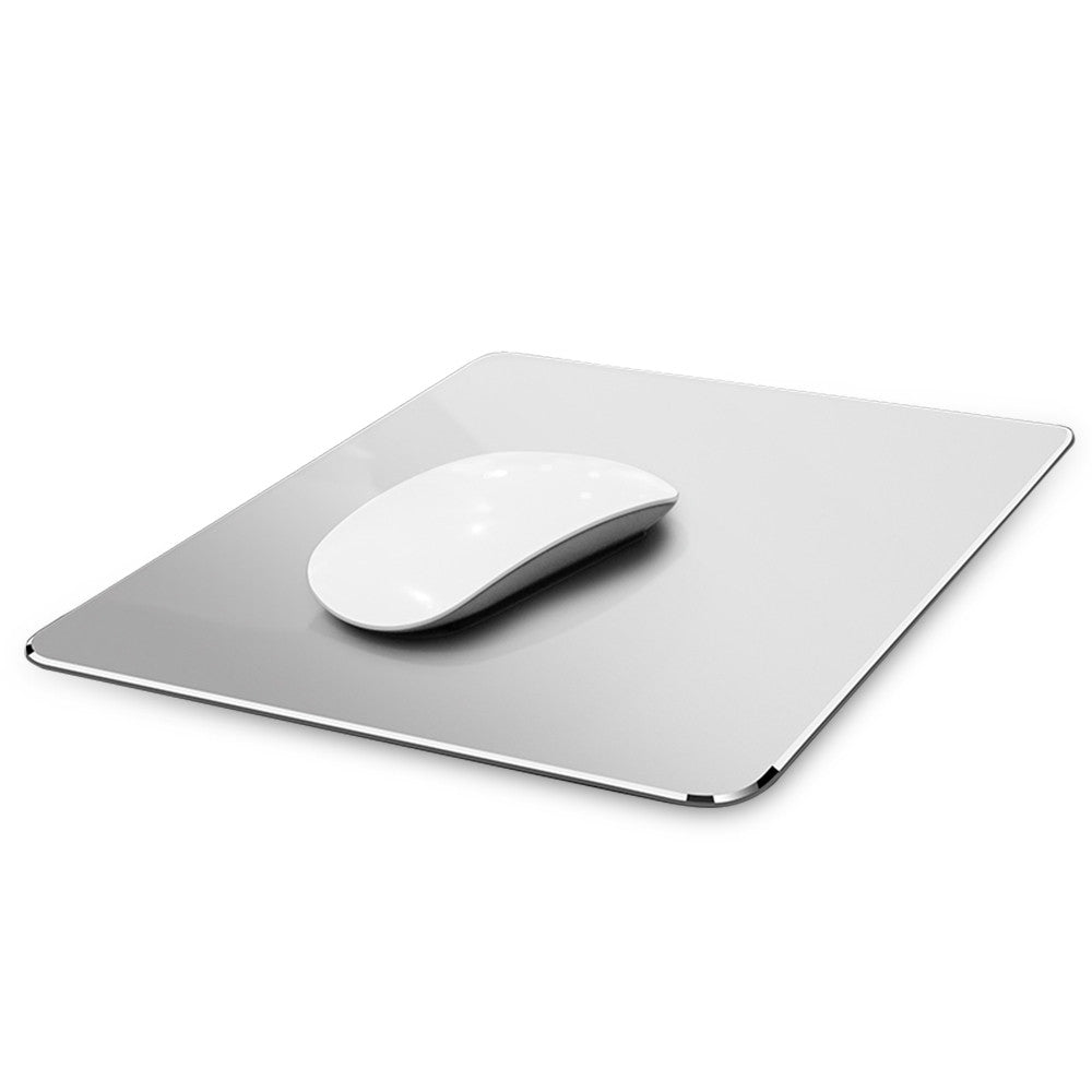A sleek white computer mouse rests on a reflective, minimalist grey mousepad with rounded edges, set against a white background.