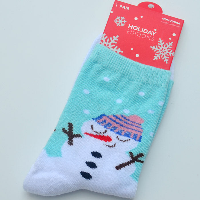 Turquoise and white socks with a snowman wearing a pink and blue hat, eyes closed. The packaging is red with snowflakes and reads "Holiday Editions."