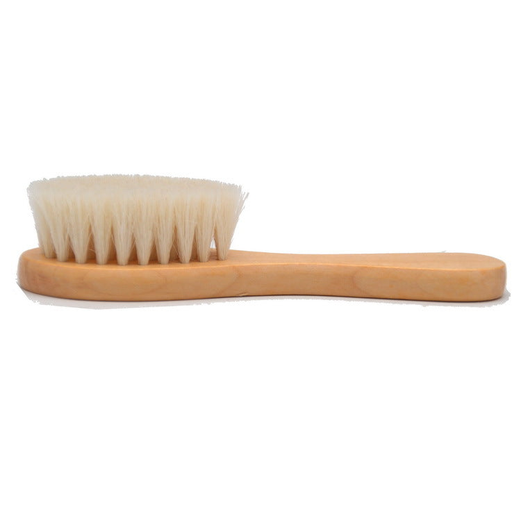 Wooden brush with soft beige bristles and an ergonomic handle, placed on a white background, ideal for gentle cleaning or grooming.