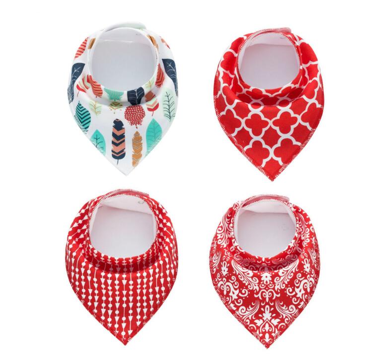 Four baby bandana bibs: top left with colorful leaf and feather design, top right with red and white geometric pattern, bottom left with red arrow design, bottom right with red floral design.