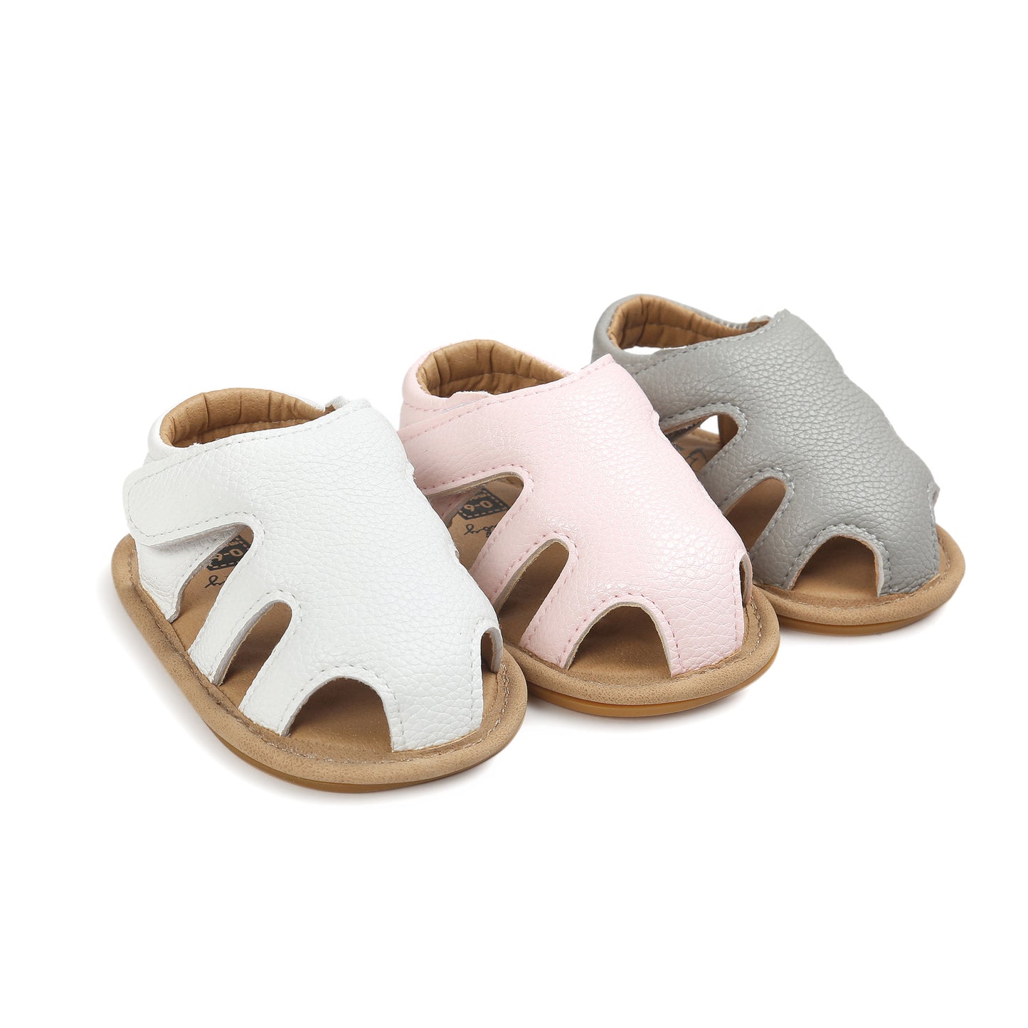 Three pairs of baby sandals in white, pink, and gray. Each has a textured faux-leather finish and open toe design, with soft soles suitable for early walkers.