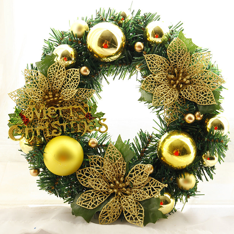 Festive Christmas wreath with golden baubles, delicate gold lace poinsettias, and lush green foliage. A "Merry Christmas" sign is adorned with holly accents.