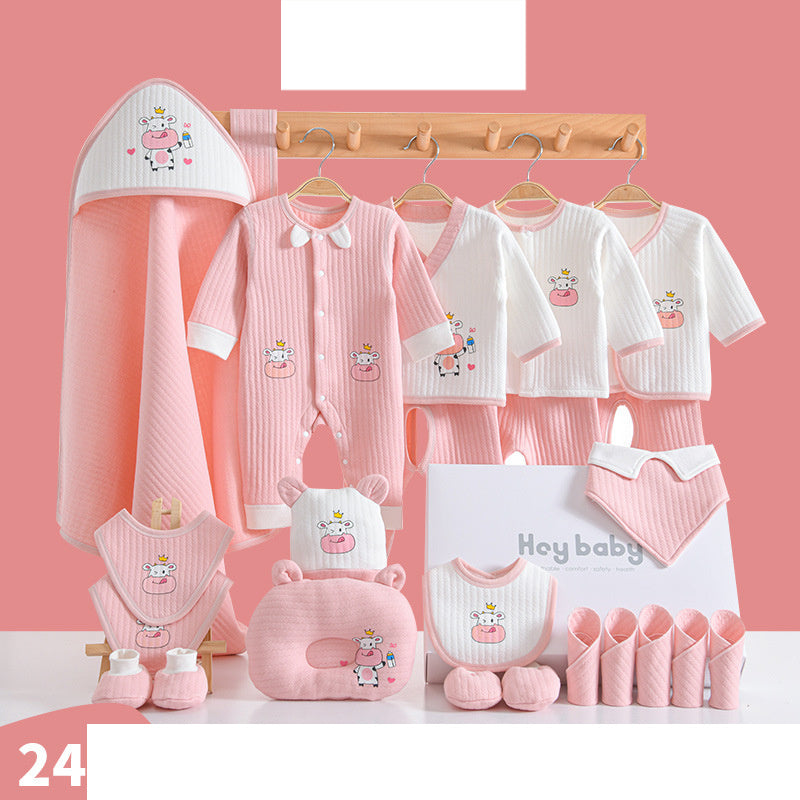 Pink and white baby clothing set with cow illustrations, including a onesie, towels, bib, hat, and booties, displayed on hangers and a table against a pink background.