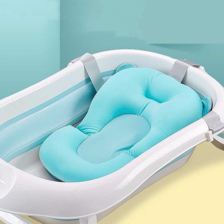 White baby bathtub with a soft, blue cushioned insert, designed for infant comfort and safety. The tub is set against a two-toned green and yellow background.