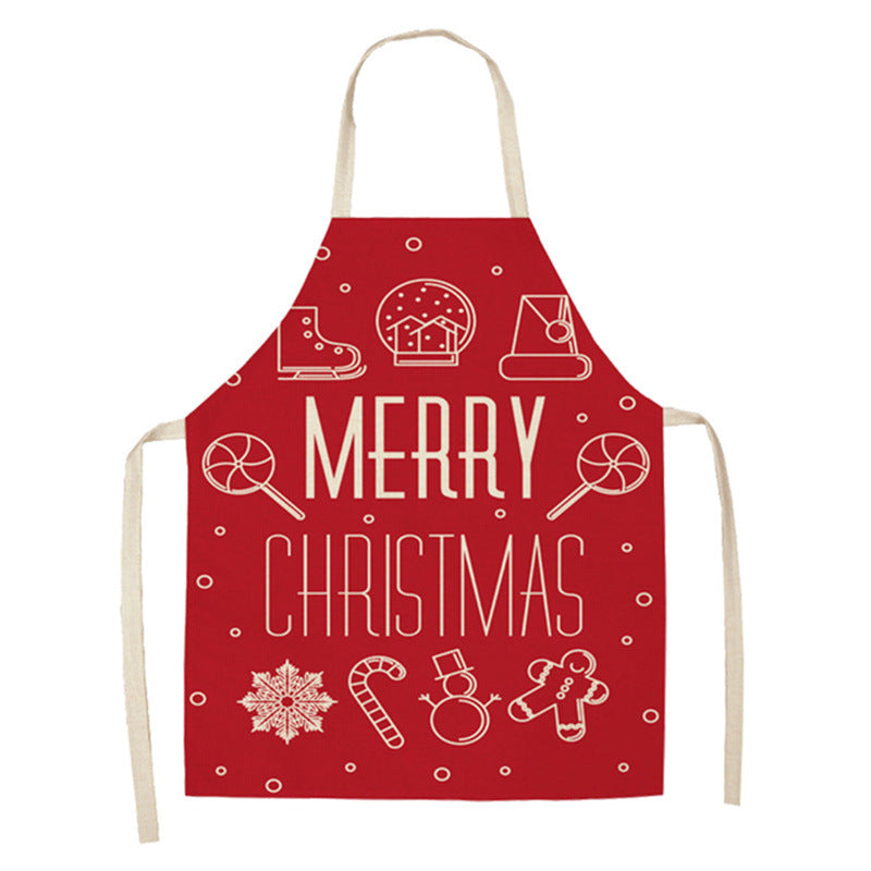Red apron with white "Merry Christmas" text and holiday icons: gingerbread man, candy cane, snowflake, snow globe, Santa hat, lollipops, and snowball. Beige straps and ties.