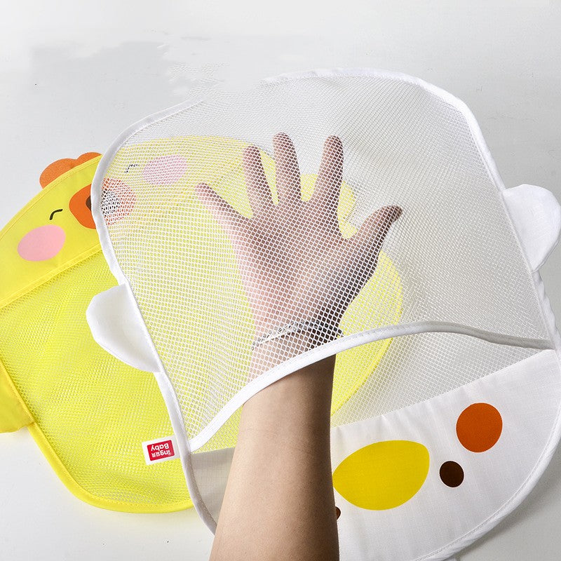 A hand stretches a white mesh lid over a cute yellow duck-shaped laundry bag on a white surface, featuring cartoon eyes and cheeks.