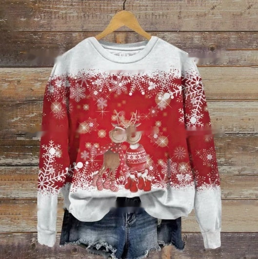 Red and white holiday sweater featuring a reindeer in a festive outfit surrounded by various snowflake patterns. The sweater is paired with denim shorts, hanging on a wooden wall.