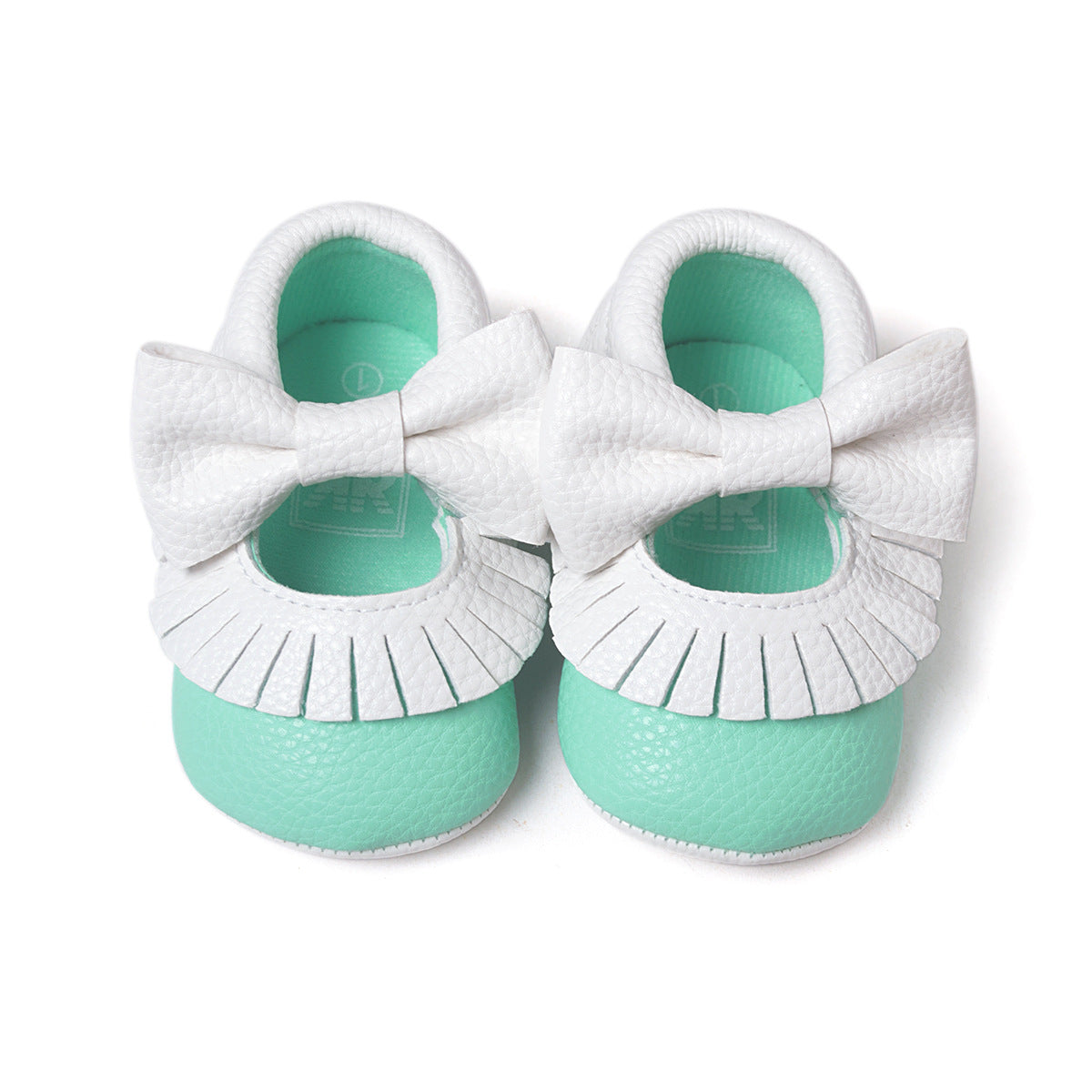 Mint green baby shoes with textured white bows and fringed trim.